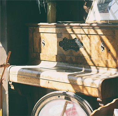 Une photo d'un piano rustique éclairé par un rayon de soleil