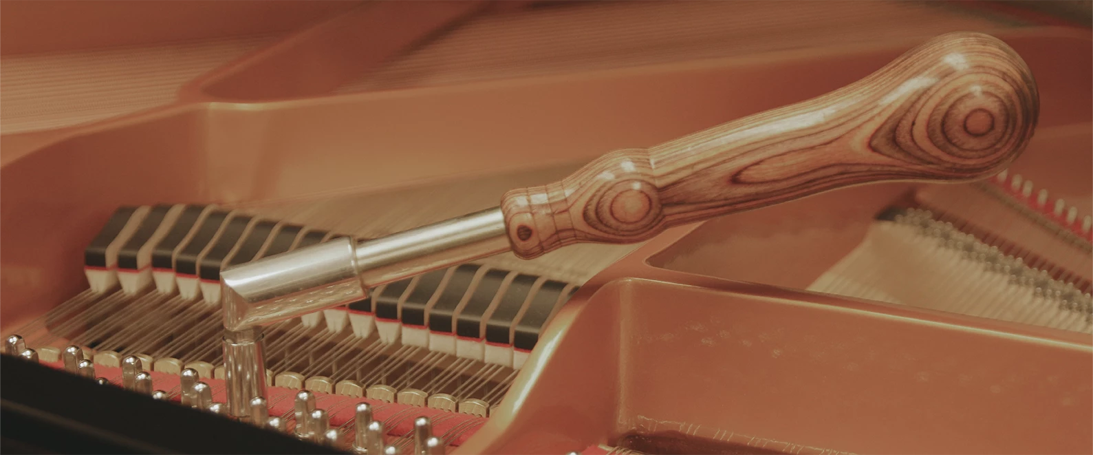 Une photo d'un outil pour accorder un piano, posé sur un mécanisme de piano.